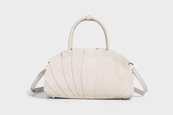 Structured dome satchel with fan-pleated leather-look exterior, dual top handles, and detachable shoulder strap, detail view