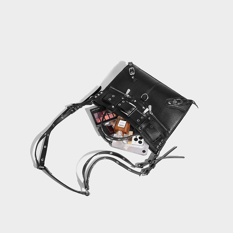 Black structured rectangular satchel bag with silver-tone rivets, large front buckle strap, zip pockets, dual top handles