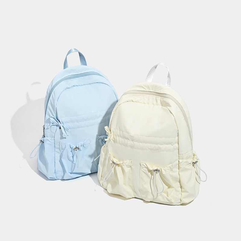 Puffy matte nylon mini backpack with drawcord gathered front pockets and silver-tone hardware, detail view 2