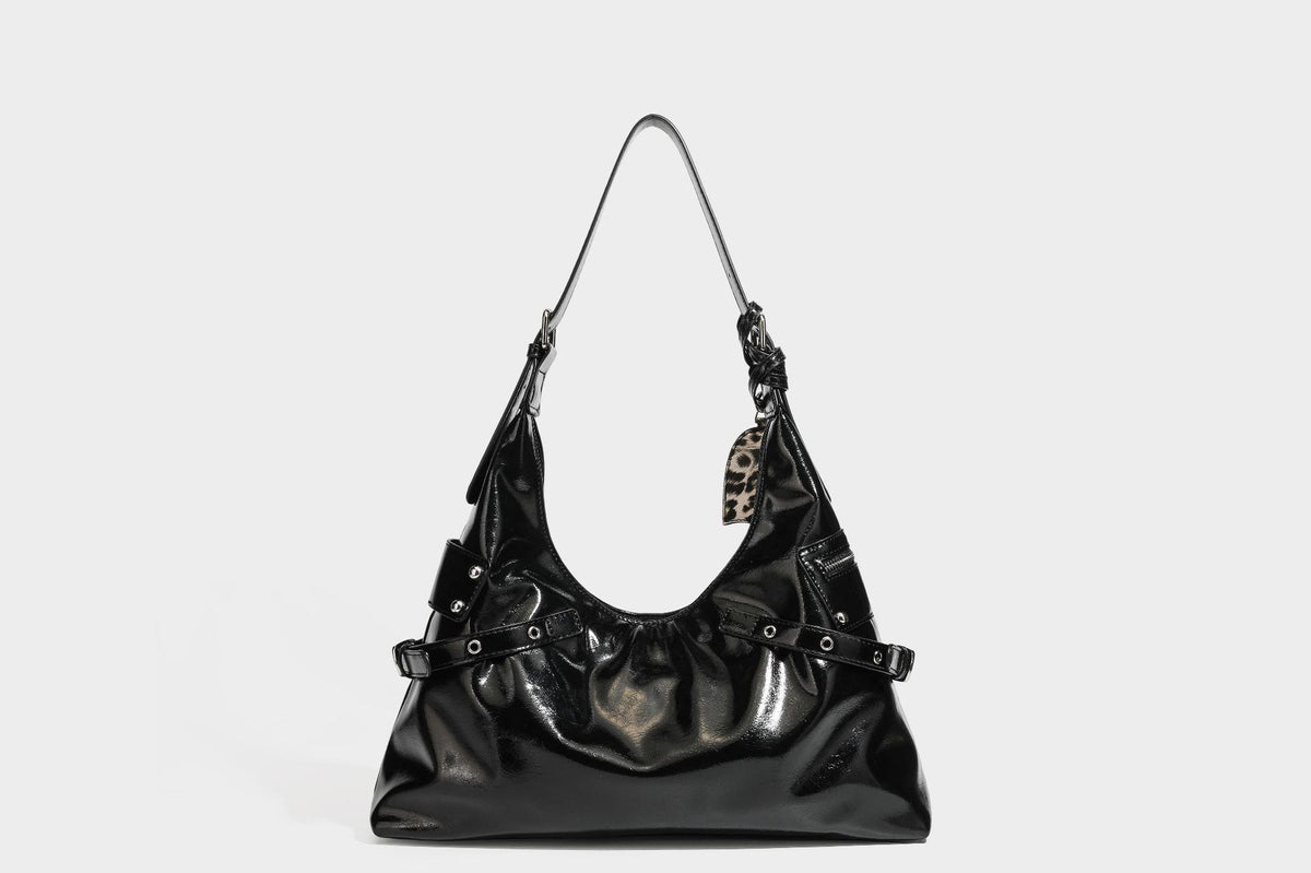 Glänzende dunkelbraune, lässig geschnittene Hobo-Schultertasche mit Riemendetail mit silberfarbenen Ösen, Reißverschlussfach auf der Vorderseite und Herz mit Leopardenmuster