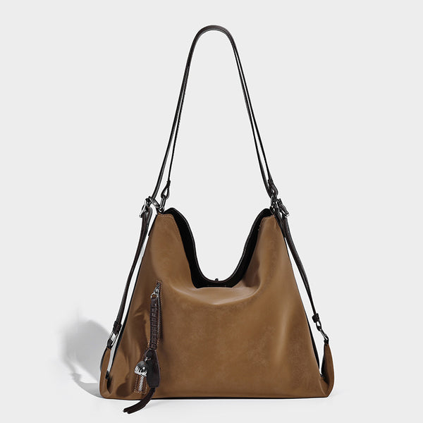 Slouchy hobo tote bag with matte leather-look finish, triangular silhouette, front zip pocket, and adjustable shoulder strap