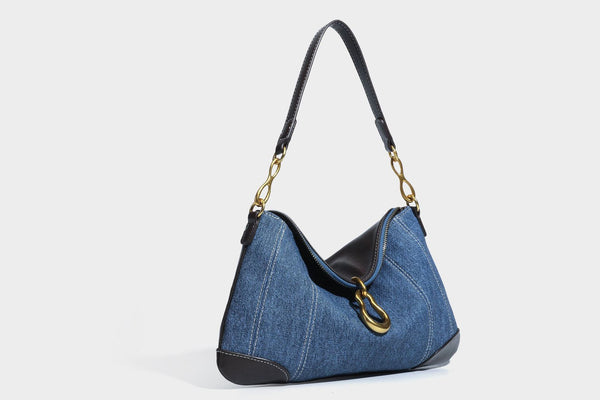 Slouchy denim shoulder bag with dark leather-look trim, gold-tone chain-link hardware, and top zipper closure, detail view 26