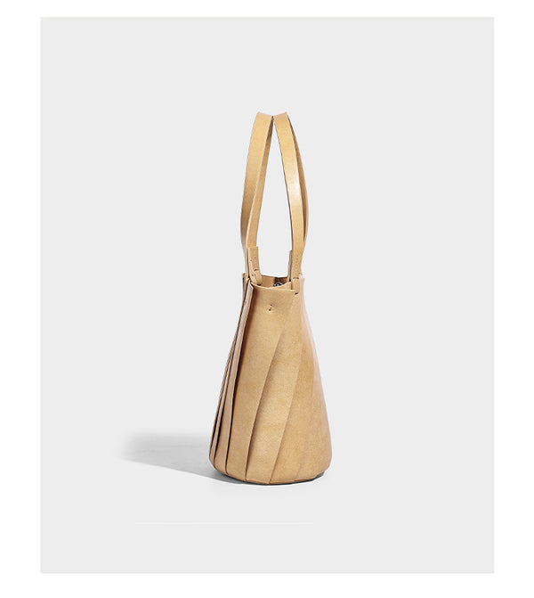 Structured bucket tote bag with vertical panel exterior, dual top handles, and detachable shoulder strap in tan leather-look