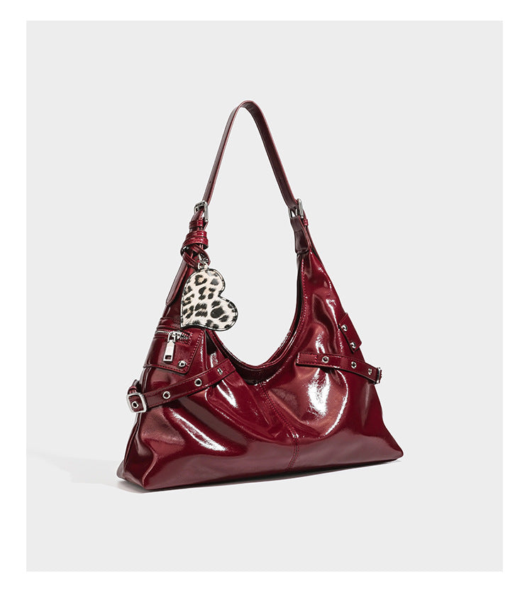 Glänzende, dunkelbraune Hobo-Schultertasche mit silberfarbenen Ösen am Riemen, vorderer Reißverschlusstasche und Herzmotiv im Leopardenprint