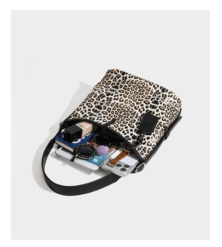 Slouchy leopard print shoulder hobo bag with black leather-look trim, tie-top closure, and single long strap, detail view 12