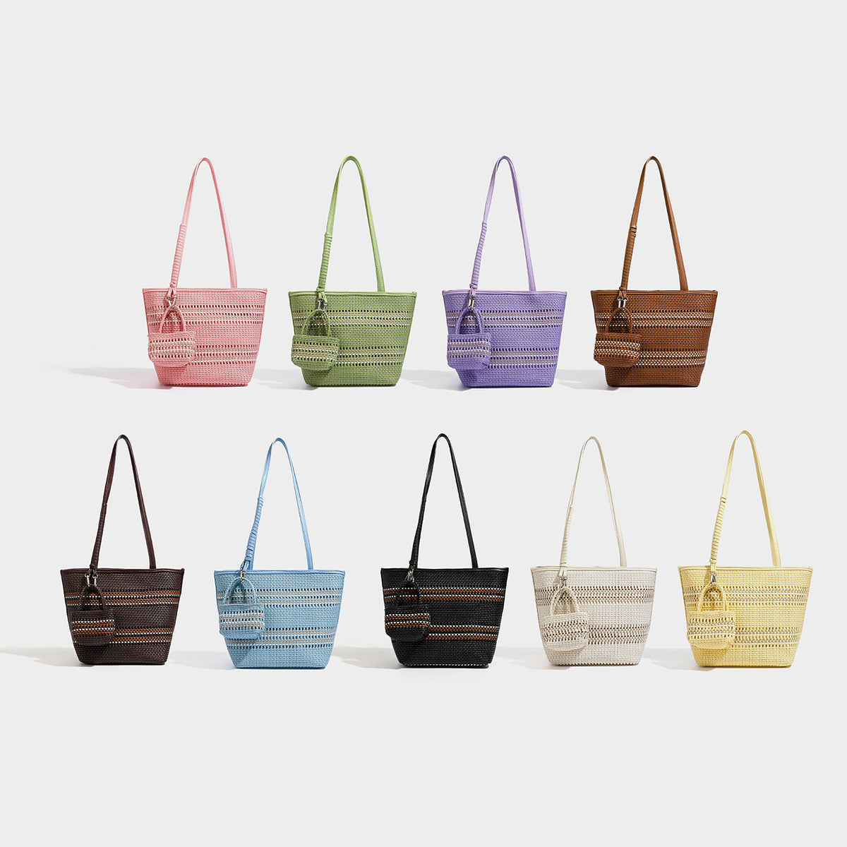 Large structured woven tote bag with striped basket-weave finish, long shoulder straps, and detachable mini pouch charm