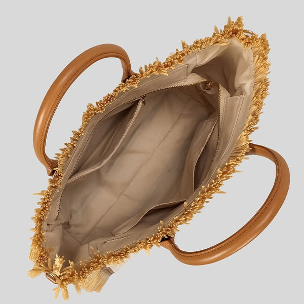 Naturfarbene, elfenbeinfarbene Strohtasche mit gewebter Optik, Bastfransenbesatz, cognacfarbenen Henkeln in Lederoptik und aufgesticktem Schriftzug „Paris Milano“