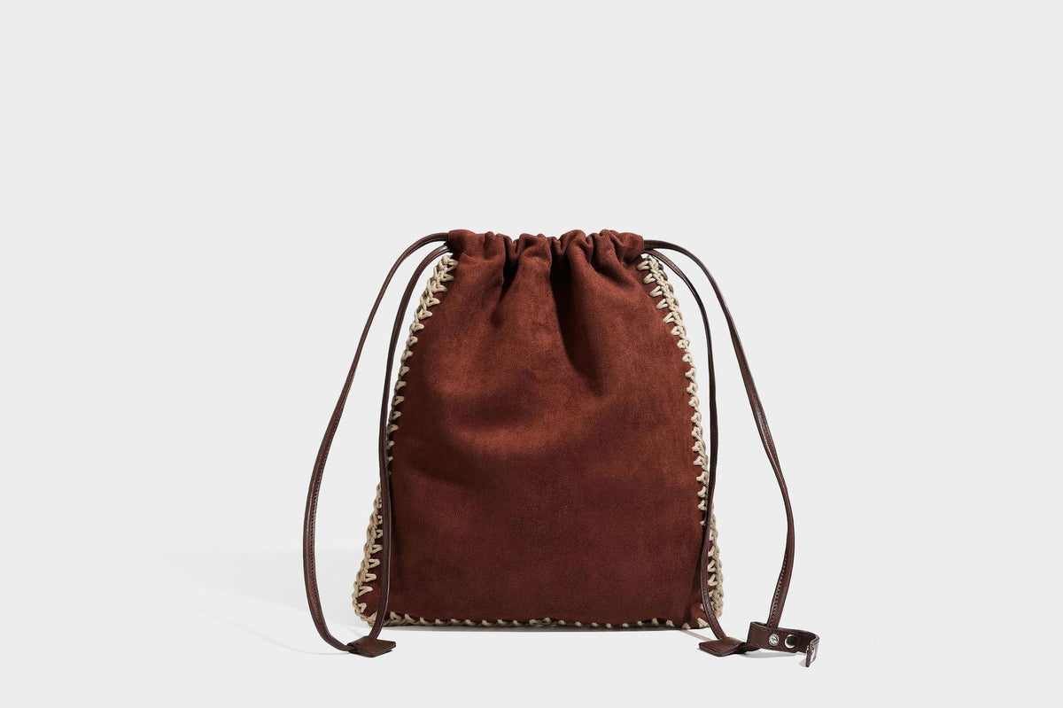Matte suede-look drawstring bucket bag with cream braided woven edge trim and slim adjustable leather-look shoulder strap
