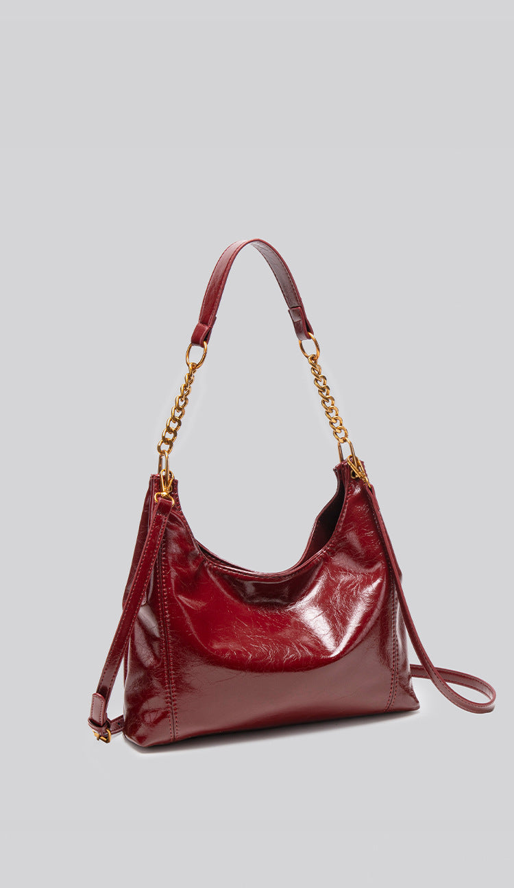Glossy leather-look hobo shoulder bag with gold-tone chain-and-leather strap in deep burgundy red, detail view 10