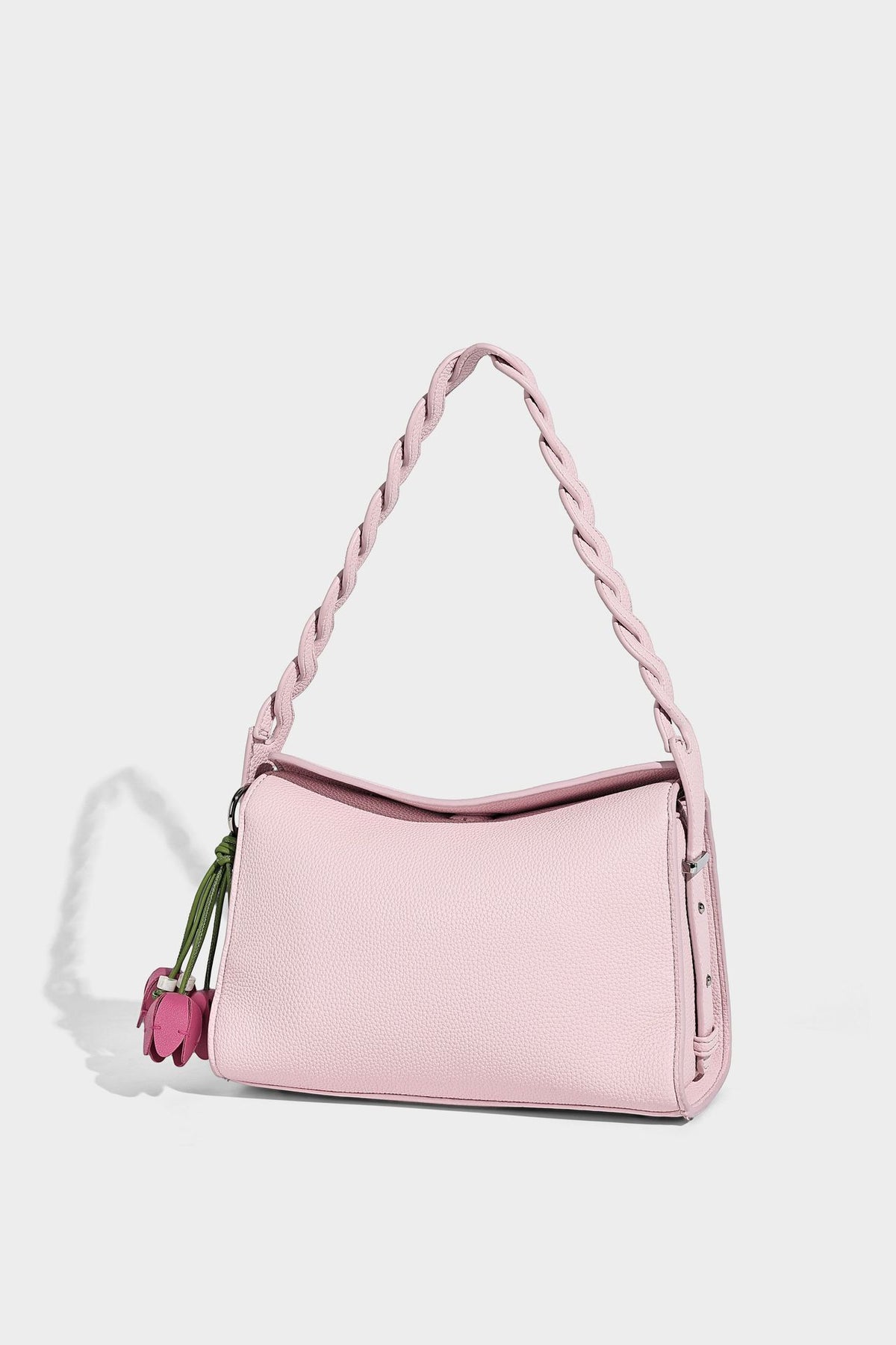 Small structured pebbled-finish shoulder bag with braided top handle, detachable crossbody strap, floral tassel charm, and