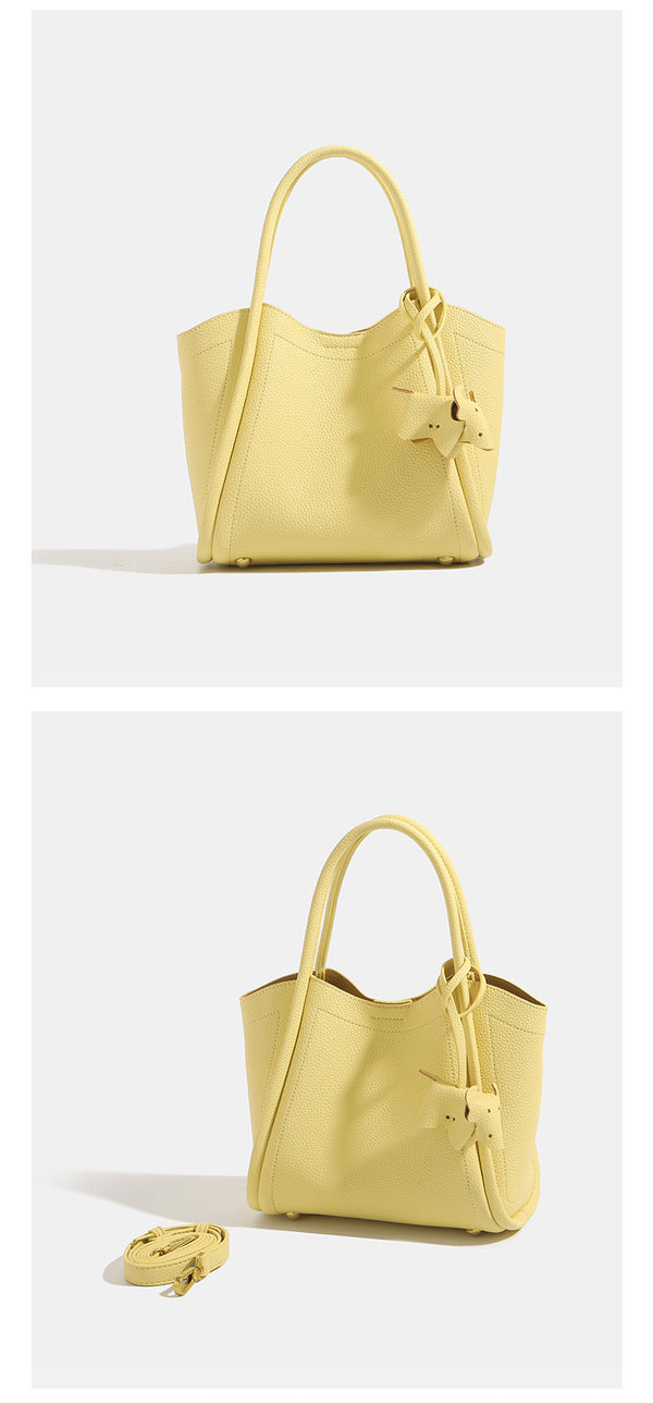 Small structured pebbled leather-look bucket tote bag with bow charm tie closure and gold-tone hardware, detail view 11