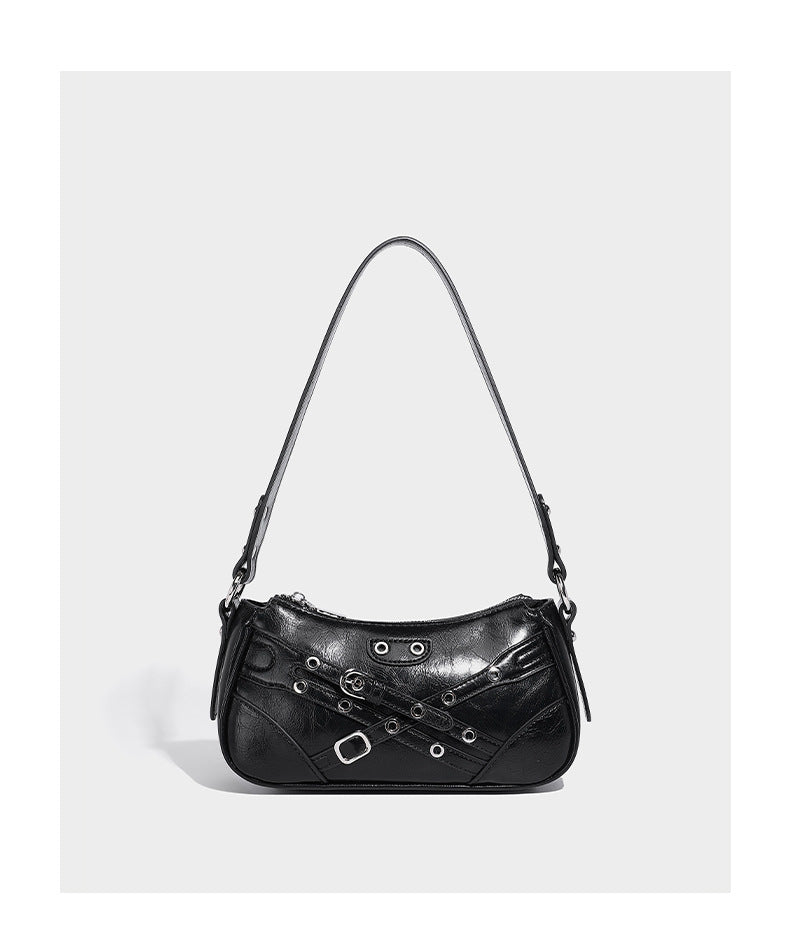 Compact moto-inspired shoulder bag with crisscross grommet strap detail, glossy textured finish, and adjustable crossbody