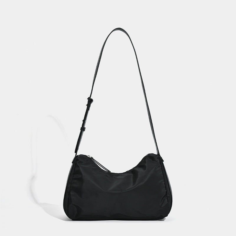 Soft crescent shoulder bag in smooth sheen nylon with contrast leather-look trim, slim adjustable strap, and top zip closure