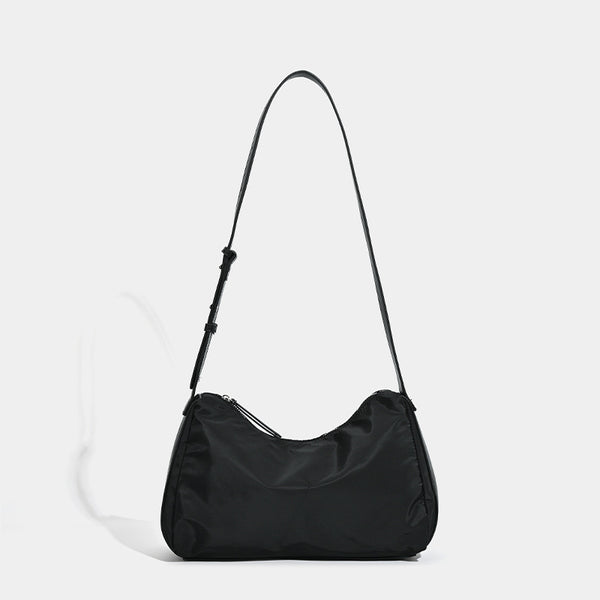 Soft crescent shoulder bag in smooth sheen nylon with contrast leather-look trim, slim adjustable strap, and top zip closure
