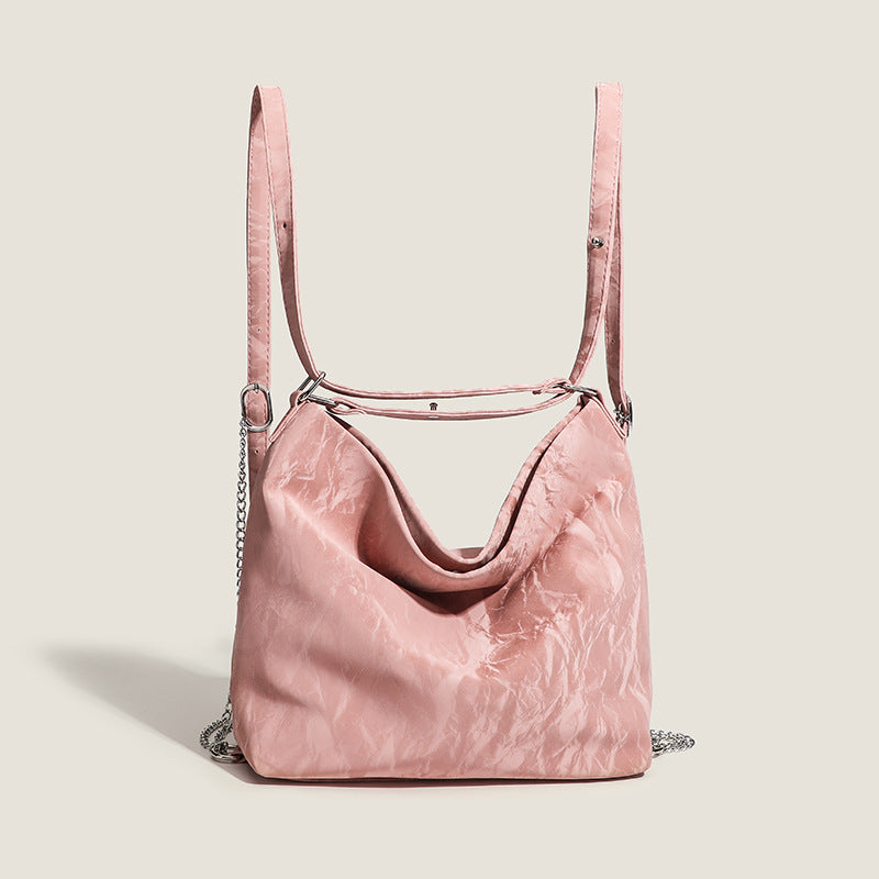 Blush pink slouchy hobo bag with crinkled sheen finish, silver-tone chain hardware, and adjustable shoulder strap, detail