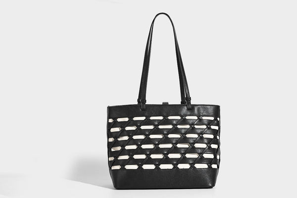 Structured woven lattice cutout tote bag with smooth leather-look trim, dual shoulder straps, and silver-tone hardware