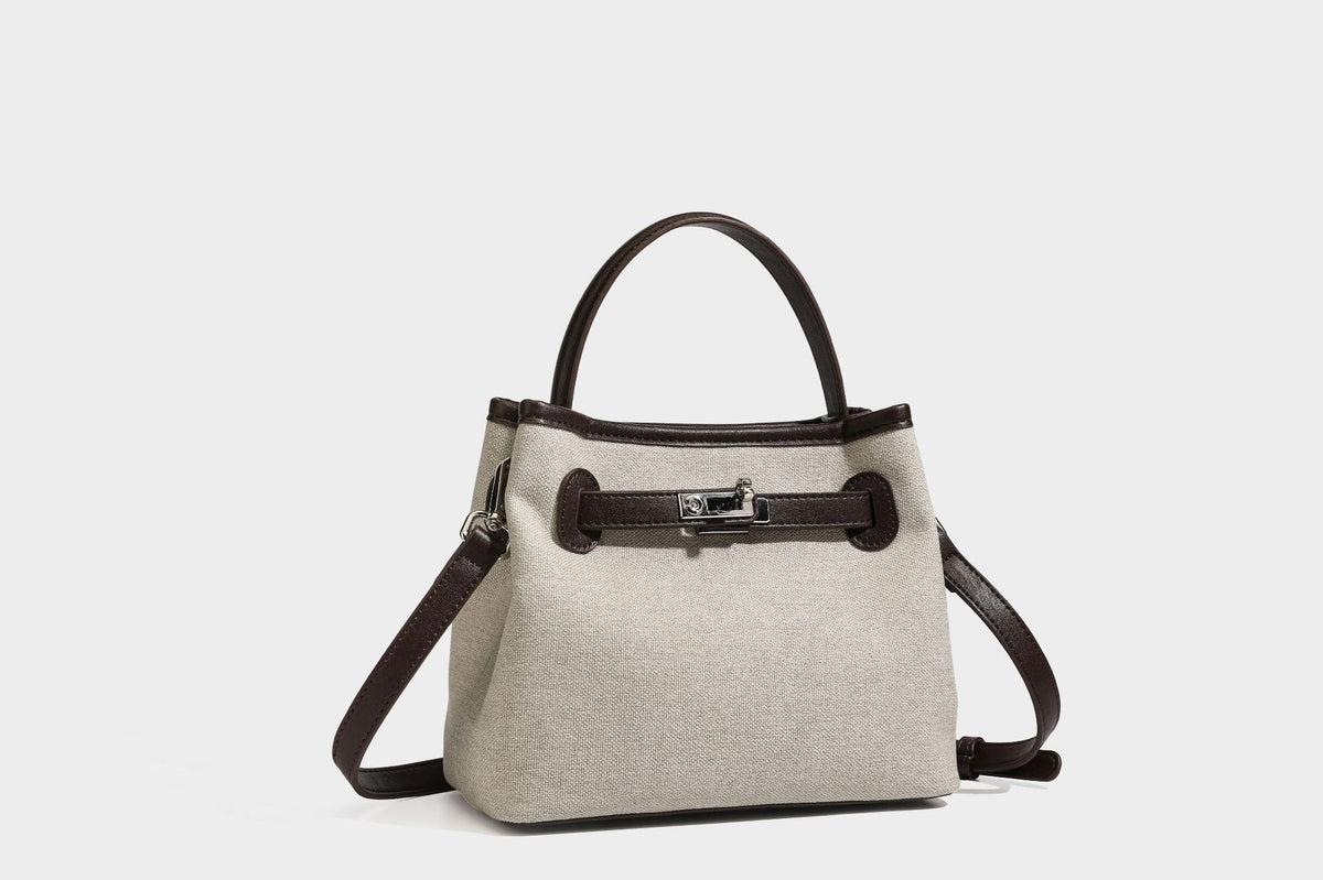 Small structured beige canvas top-handle bag with dark brown leather-look trim, silver turn-lock hardware, and detachable