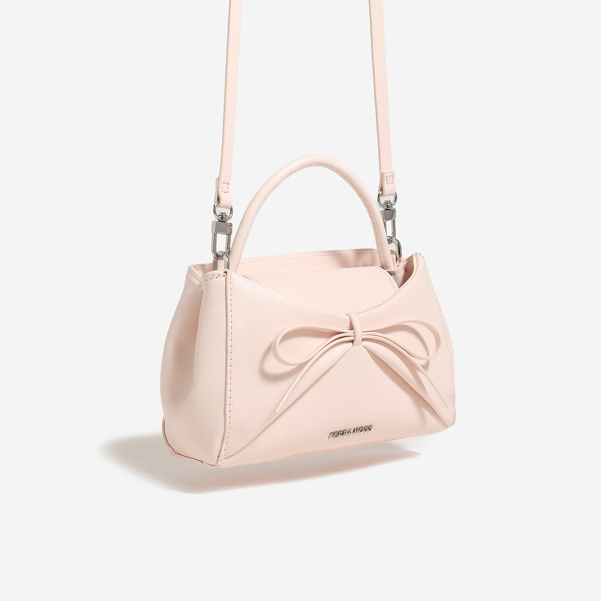 Structured mini trapezoid top-handle crossbody bag with sculpted bow front detail, smooth matte finish, silver-tone hardware
