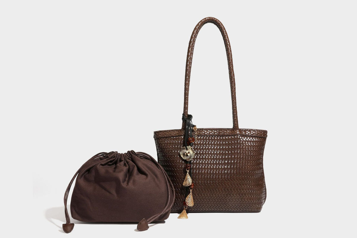 Structured woven leather-look tote bag in dark brown with long shoulder straps, side drawstring ties, and gold filigree