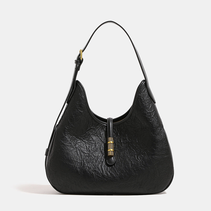 Slouchy teardrop shoulder bag in crinkled leather-look finish with gold-tone tab closure and adjustable strap, front view