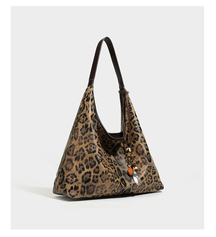Weich fallende Hobo-Tote-Bag mit Leopardenmuster in Beige und Braun, dunkelbraunem Riemen in Lederoptik und herabhängenden Perlenanhänger-Beschlägen