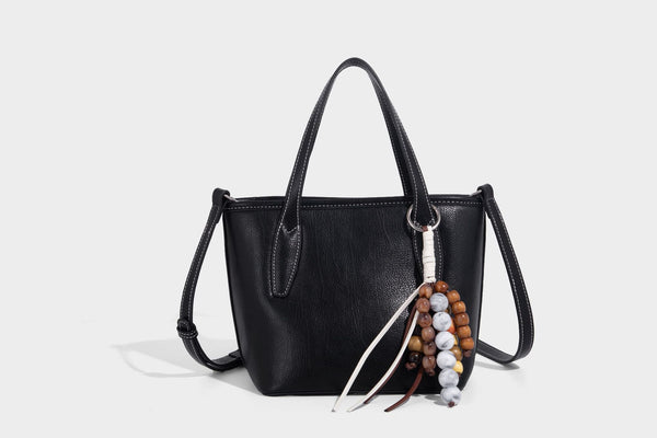 Compact structured bucket tote bag with pebbled textured finish, dual top handles, silver-tone lock hardware, and detachable