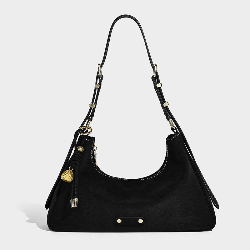 Crescent hobo shoulder bag in pebbled leather-look finish with top zipper, adjustable strap, gold-tone ring hardware, and