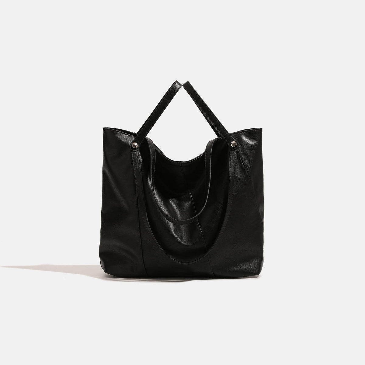 Large black leather-look soft tote shoulder bag with dual flat straps and silver-tone stud rivets, detail view 2
