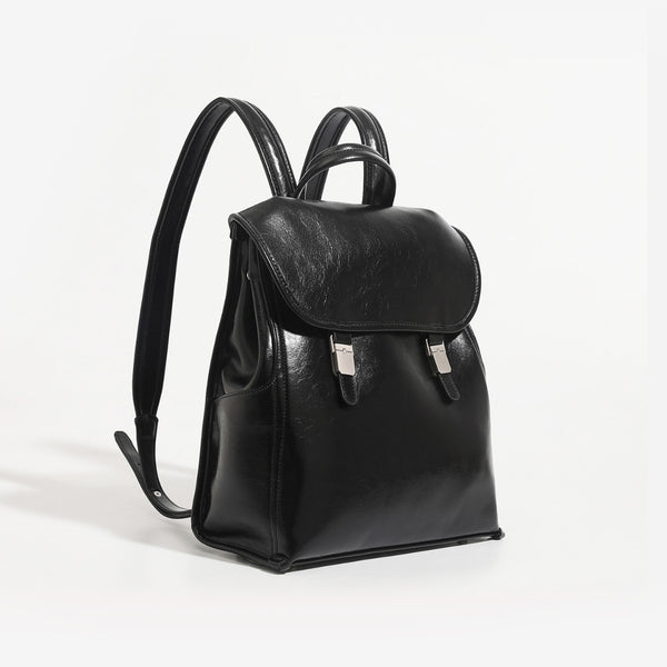 Structured glossy leather-look flap backpack handbag with dual buckle closures, top handle, and silver-tone hardware, detail