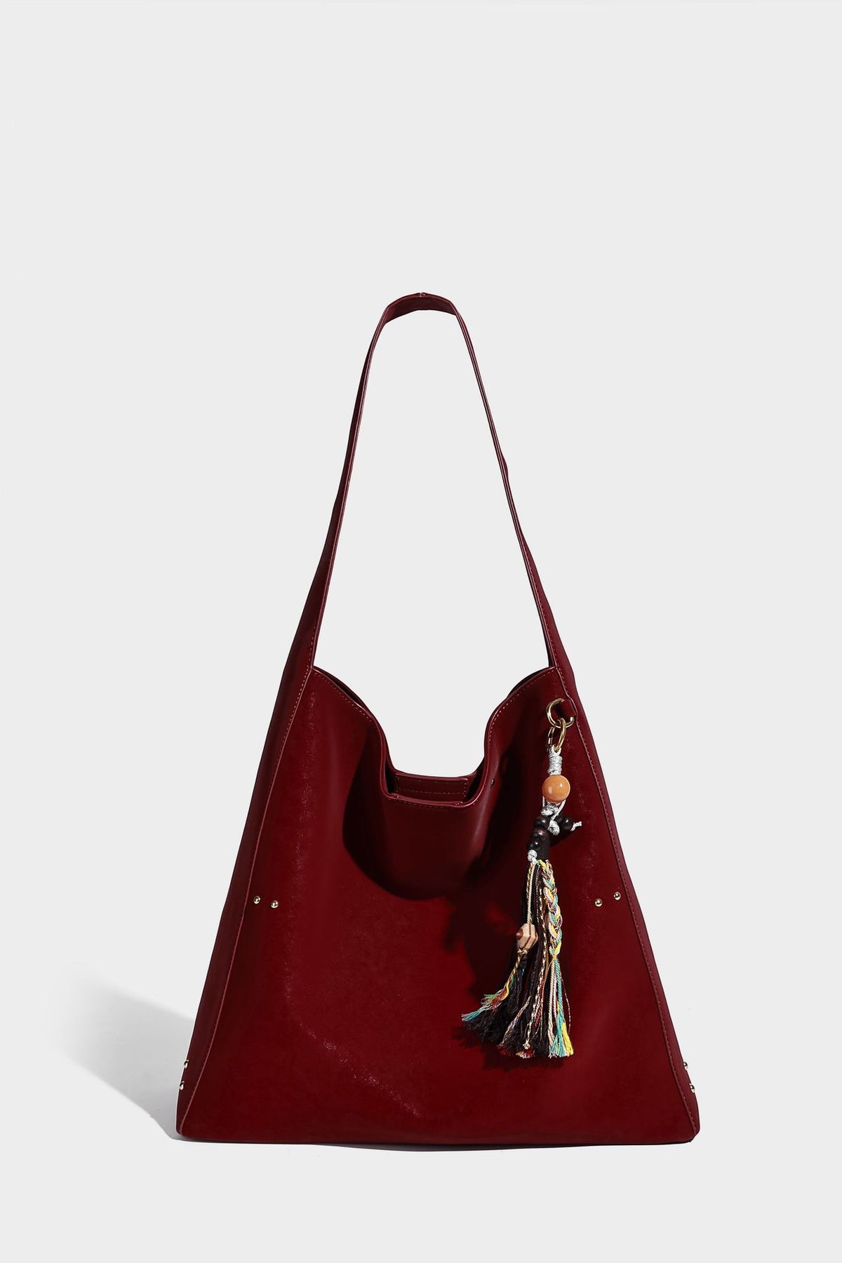 Oversized trapezoid tote bag with matte leather-look finish, gold-tone rivets, and long shoulder strap, detail view 14