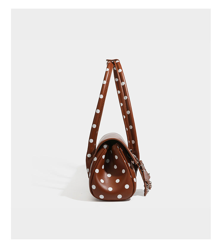 Strukturierte Baguette-Tasche mit Polka-Dot-Muster, glänzender Lederoptik, zwei Tragegriffen, silberfarbener Drehverschlussklappe und