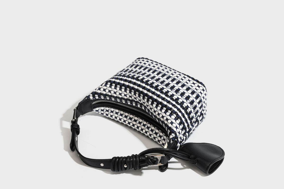 Small crescent shoulder bag in black-and-white woven textile with smooth black leather-look trim, zip-top closure, knotted