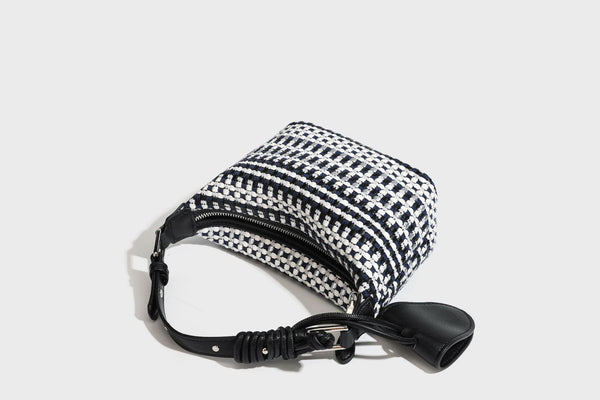Small crescent shoulder bag in black-and-white woven textile with smooth black leather-look trim, zip-top closure, knotted