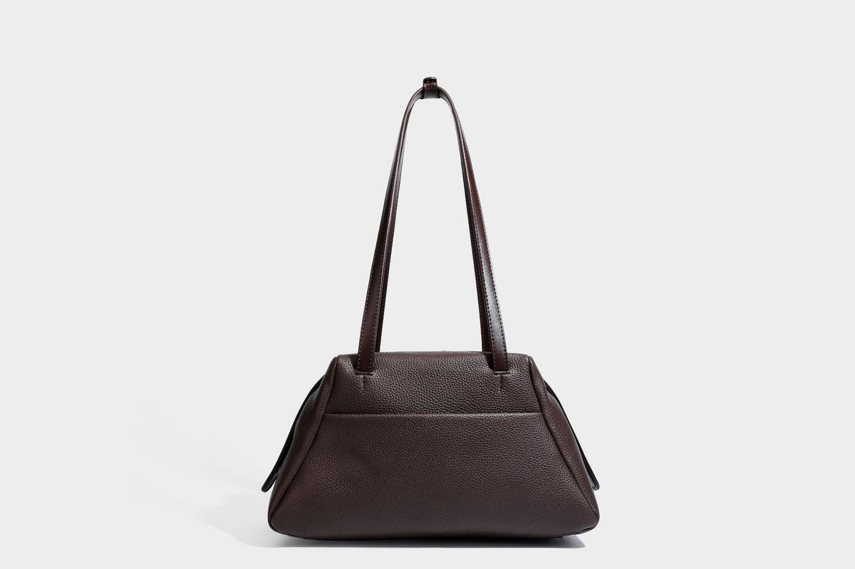 Structured trapezoid shoulder bag in dark brown pebbled leather-look finish with slim double straps, top zip closure, side