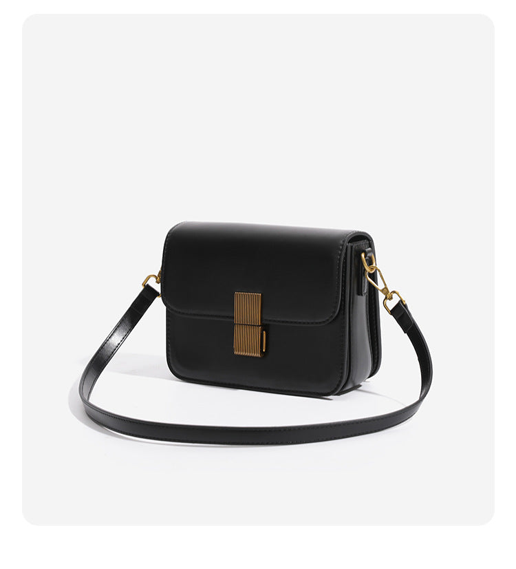Mini structured black flap crossbody bag with gold-tone ribbed rectangular clasp and adjustable shoulder strap, detail view 8