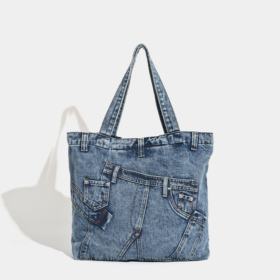 Large washed denim tote bag with jeans-style patch pocket and riveted seam detailing, double shoulder straps, open top, front