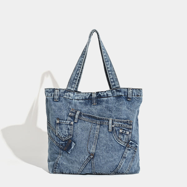 Large washed denim tote bag with jeans-style patch pocket and riveted seam detailing, double shoulder straps, open top, front