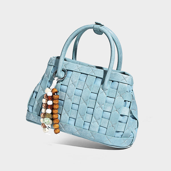 Small structured woven satchel tote with rounded top handles, silver-tone ring hardware, and bead tassel charm, detail view 9