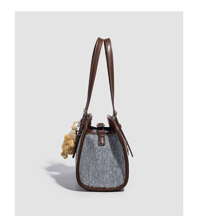 Small structured grey fabric shoulder bag with brown leather-look trim, gold-tone hardware, dual top handles, and detachable