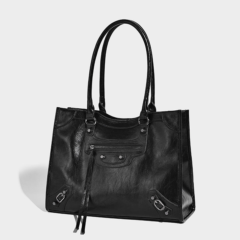 Large structured leather-look tote bag with front zip pocket, moto hardware accents, and long double shoulder straps, front