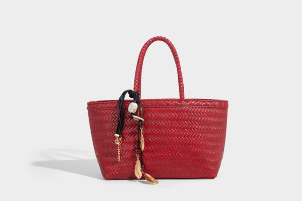 Structured chevron woven leather-look tote bag with braided top handles, gold feather charm, and adjustable shoulder strap