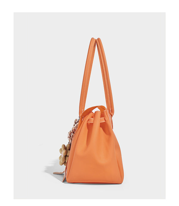 Strukturierte matte Jelly-Tote-Bag mit goldfarbenem Drehverschluss an der Klappe, zwei Schulterriemen, seitlichen Einsätzen und dekorativen