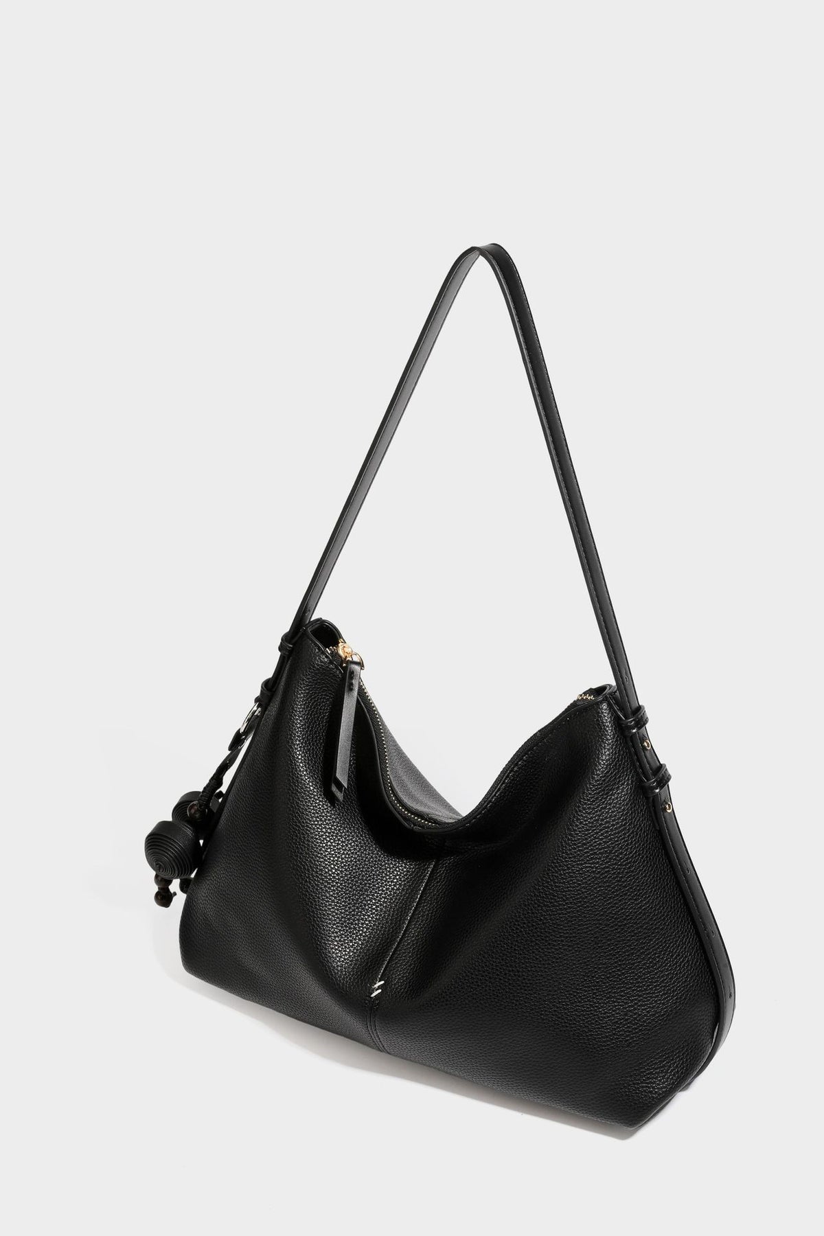 Slouchy hobo shoulder bag with pebbled leather-look finish, zip-top closure, gold-tone hardware, and hanging bead charm