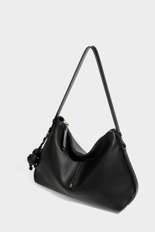 Slouchy hobo shoulder bag with pebbled leather-look finish, zip-top closure, gold-tone hardware, and hanging bead charm