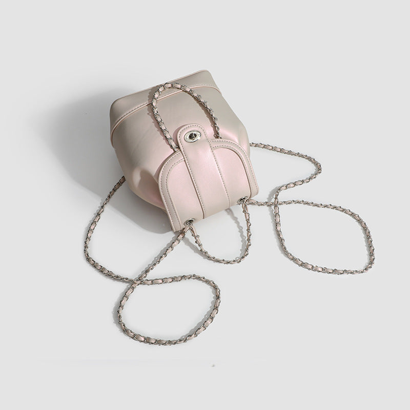 Small pearl-gloss backpack handbag with woven silver chain straps and turn-lock flap closure, detail view 4