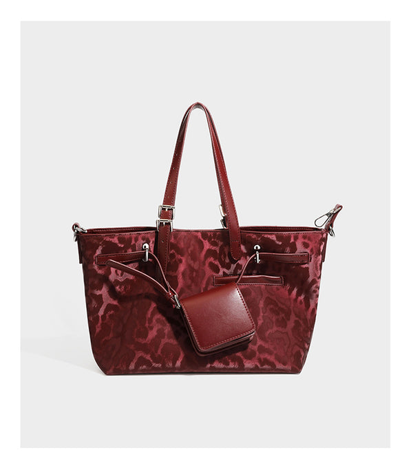 Glossy leopard-print tote bag with leather-look dark trim, dual top handles, detachable shoulder strap, and attached front