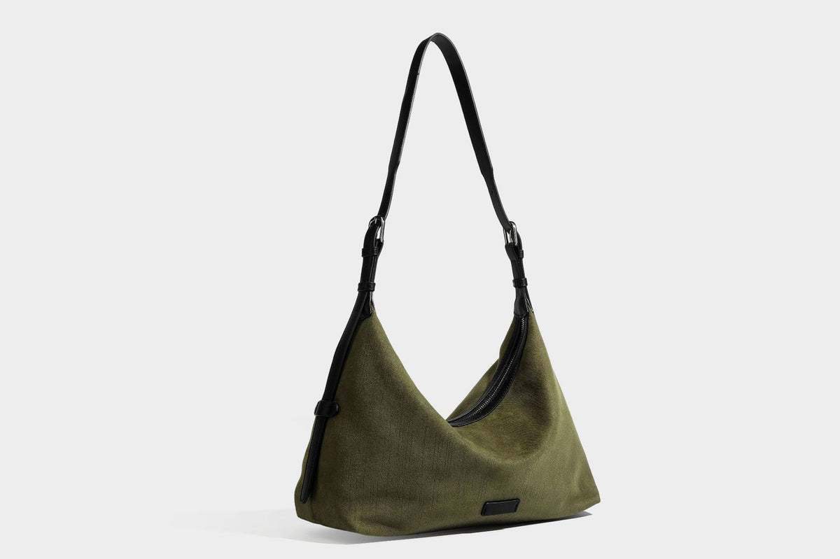 Slouchy olive green canvas hobo shoulder bag with black leather-look trim, zip-top closure, and adjustable strap, detail view