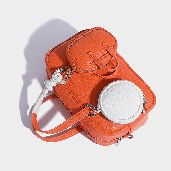 Structured pebbled leather-look Boston bowling bag in tan with blue detachable round mini pouch, dual top handles, and