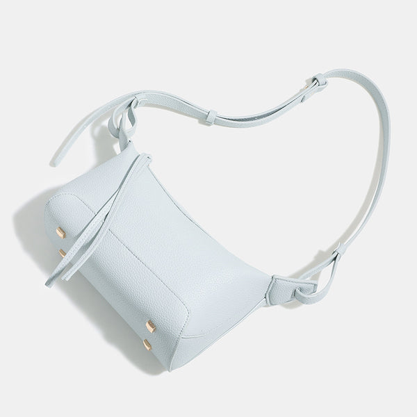 Small structured mini crossbody shoulder bag with pebbled texture, knotted adjustable strap, top zip closure, and gold-tone