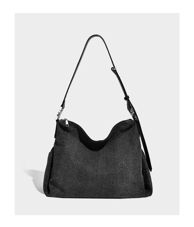 Charcoal denim-textured slouchy hobo bag with zip-top closure, silver-tone hardware, and adjustable leather-look crossbody